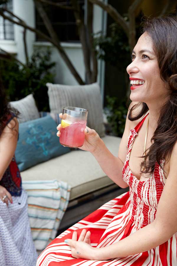 A guest laughing with a glass of pink lemonade