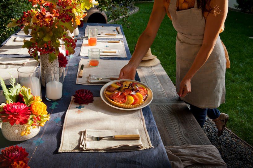 A table being set on the lawn for an outdoor dinner
