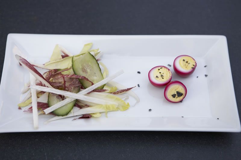 Pickled quail eggs and a crisp salad on a long white plate
